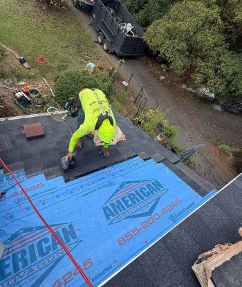 Roofer installing roof underlayment on a residential roof during leak repair